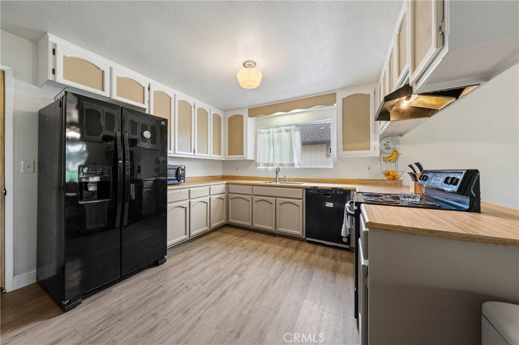 19425 Old Creek Road Hidden Valley Lake, CA 95467 - Photo 14 of 42 a kitchen with a refrigerator a sink dishwasher with a stove and wooden floor
