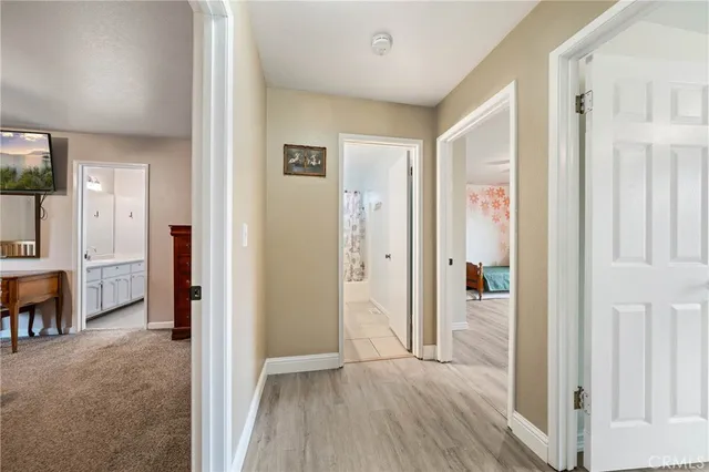 a view of a hallway with bathroom and wooden floor