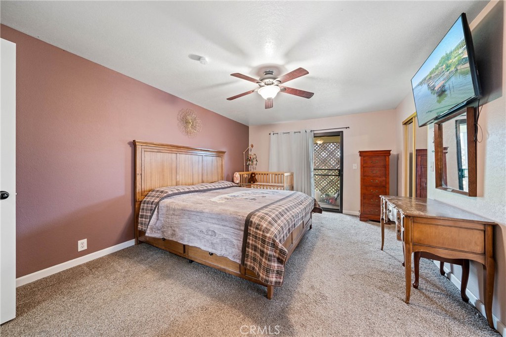 19425 Old Creek Road Hidden Valley Lake, CA 95467 - Photo 20 of 42 a bedroom with a large bed tv and a window