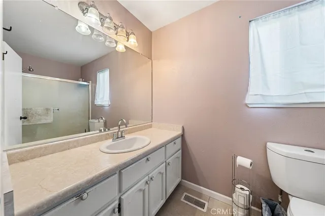 a bathroom with a granite countertop sink a toilet and a mirror