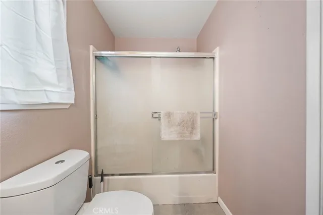 a white toilet sitting next to a shower