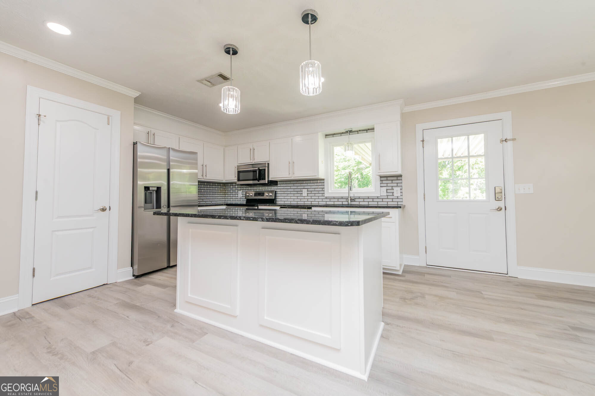 1661 Mule Creek Road Byron, GA 31008 - Photo 12 of 33 a kitchen with kitchen island granite countertop a sink cabinets and stainless steel appliances