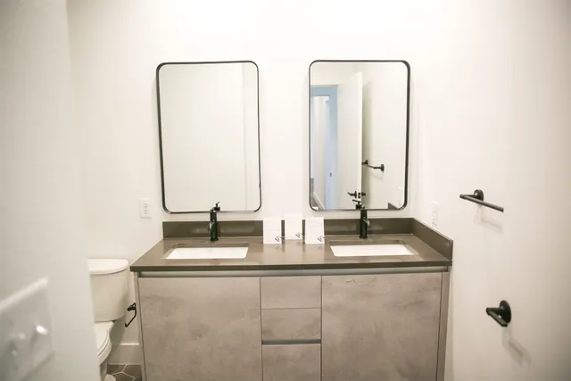 a bathroom with double vanity and a mirror