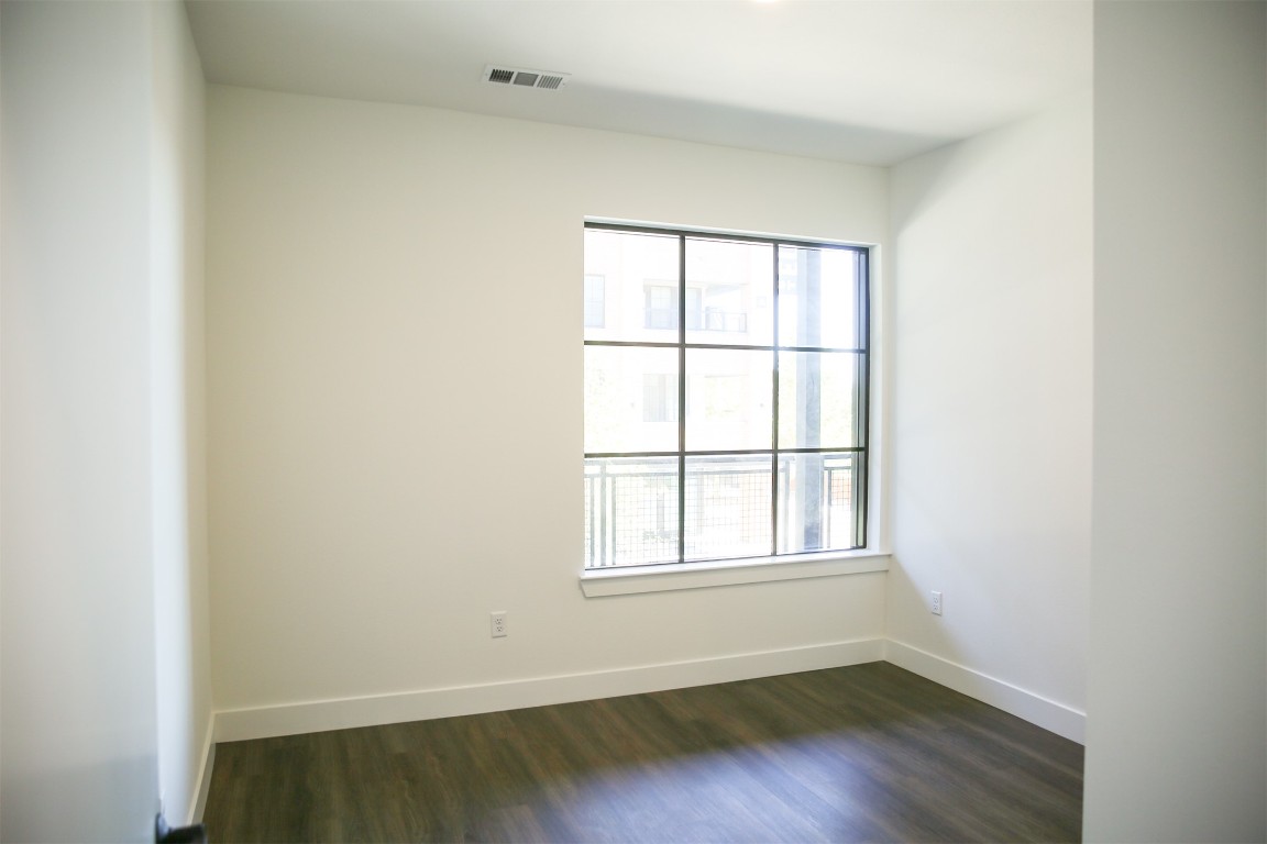 4315 South Congress Avenue, Unit 203 Austin, TX 78745 - Photo 11 of 15 an empty room with wooden floor and windows