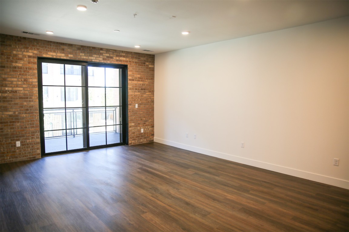 4315 South Congress Avenue, Unit 203 Austin, TX 78745 - Photo 4 of 15 a view of an empty room with wooden floor and a window