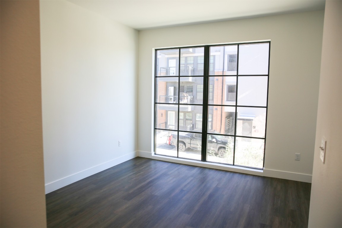 4315 South Congress Avenue, Unit 203 Austin, TX 78745 - Photo 8 of 15 an empty room with wooden floor and windows