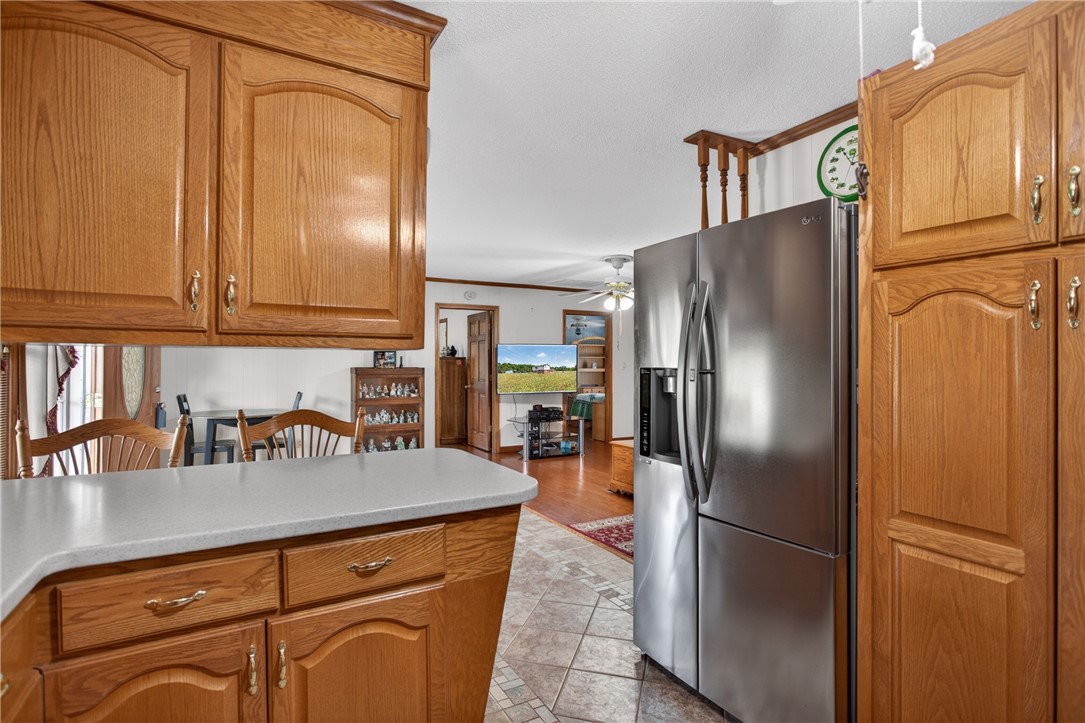 145 State Rd S-4-935 Pendleton, SC 29670 - Photo 43 of 47 A warm, inviting kitchen with wooden cabinetry and ample counter space, flowing into a comfortable living area.