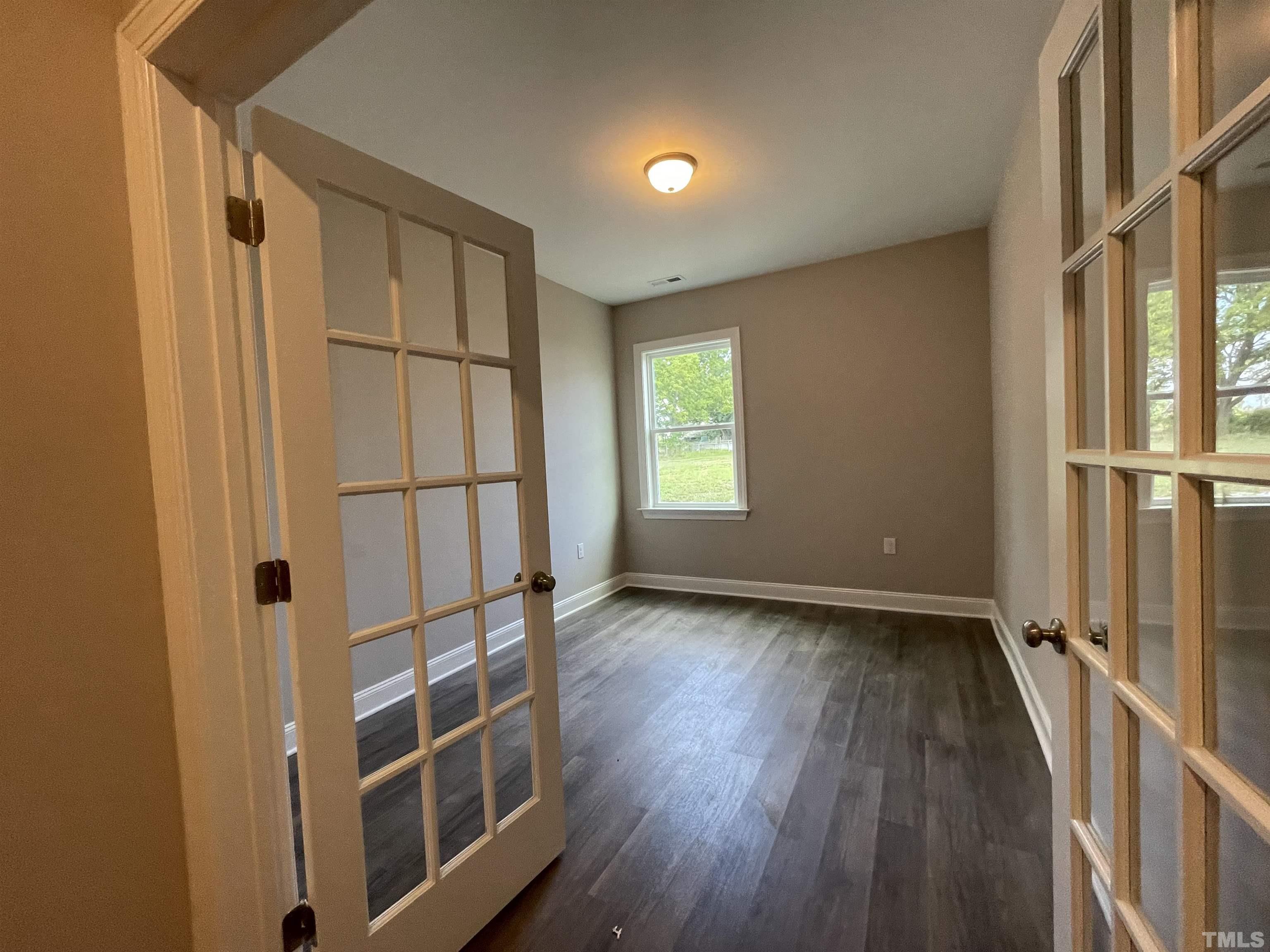 145 Wolf Ridge Willow Spring, NC 27592 - Photo 6 of 17 an empty room with wooden floor and a window
