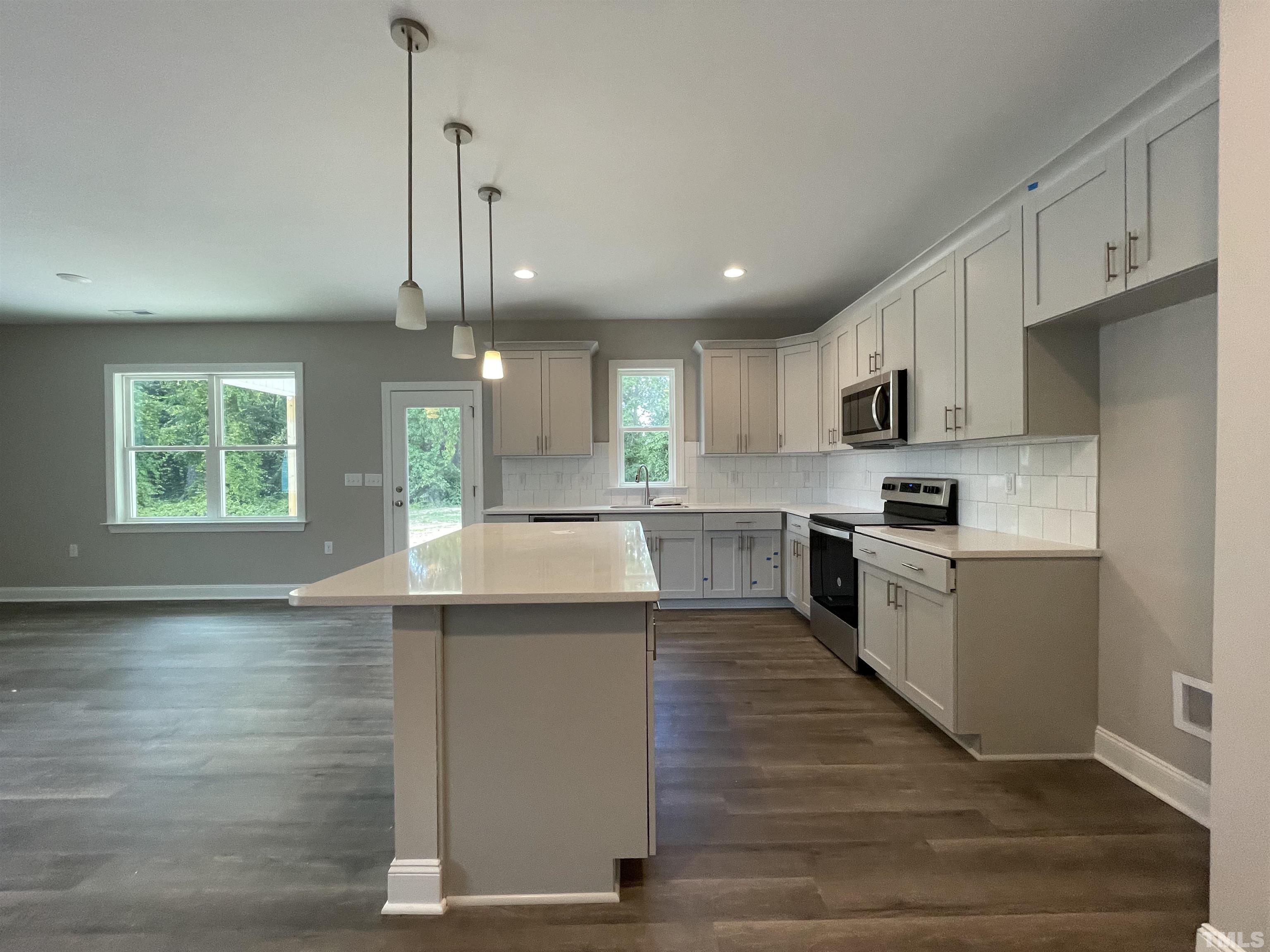 145 Wolf Ridge Willow Spring, NC 27592 - Photo 9 of 17 a kitchen with stainless steel appliances granite countertop a sink a stove and a refrigerator