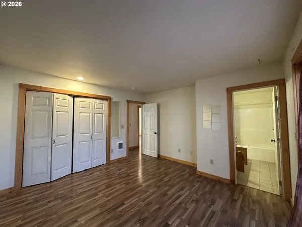 an empty room with wooden floor and sliding door