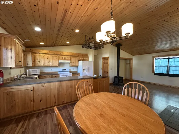 a kitchen with stainless steel appliances granite countertop a stove a sink dishwasher a couches with wooden floor