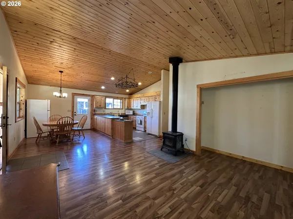a view of a livingroom with furniture and an empty room with wooden floor