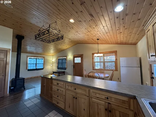 a large kitchen with a large counter space a sink appliances and cabinets