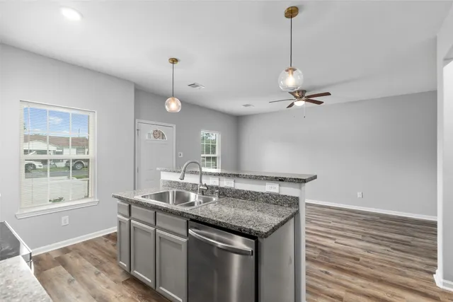 a view of a kitchen island a chandelier and wooden floor