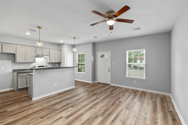 a kitchen with stainless steel appliances granite countertop a refrigerator and a stove top oven