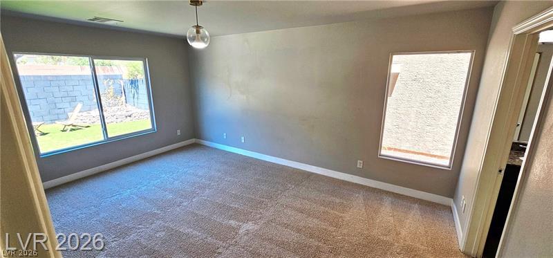 6302 Jackson Spring Road Las Vegas, NV 89118 - Photo 19 of 48 A well-proportioned room with warm carpeted flooring offers ample natural light through multiple windows.