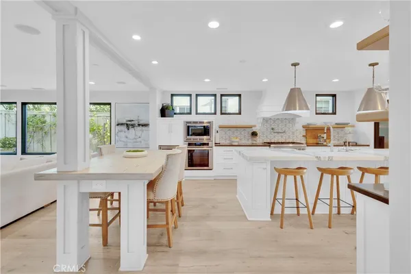 a large kitchen with kitchen island a table and chairs in it
