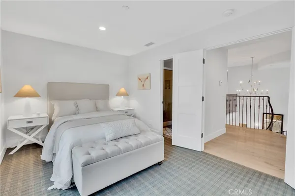 a spacious bedroom with a bed and a lamp