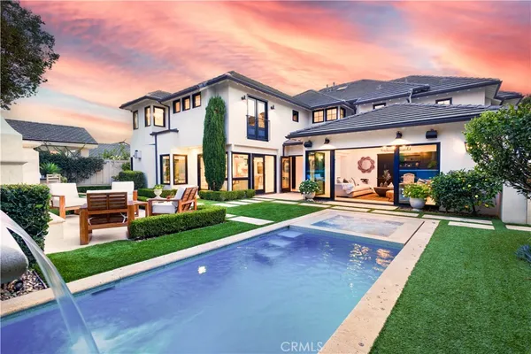 a view of house with a big yard and potted plants