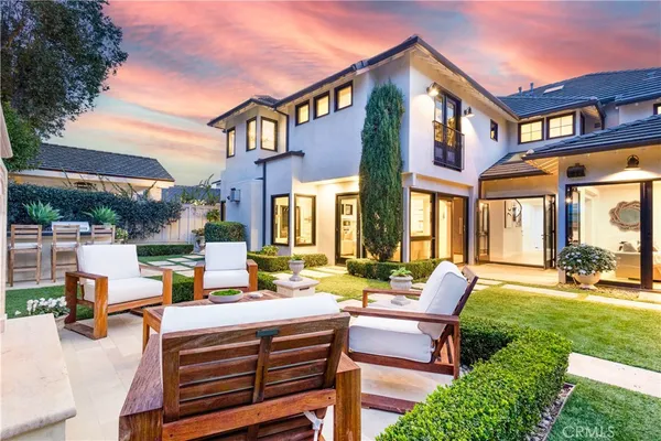 a backyard of a house with a garden and outdoor seating