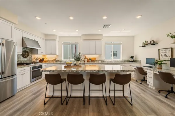 a kitchen with a dining table chairs refrigerator and cabinets