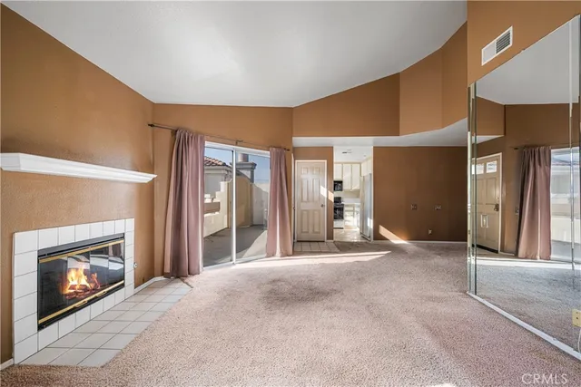a view of empty room with a fireplace and chandelier