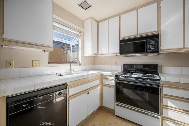 a kitchen with cabinets stainless steel appliances and a wooden floor