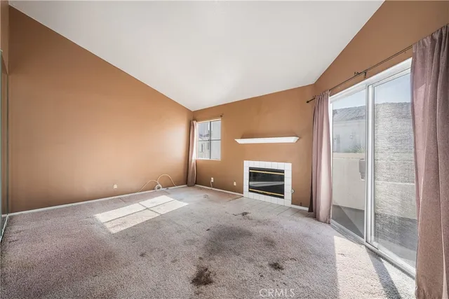 an empty room with fireplace and windows