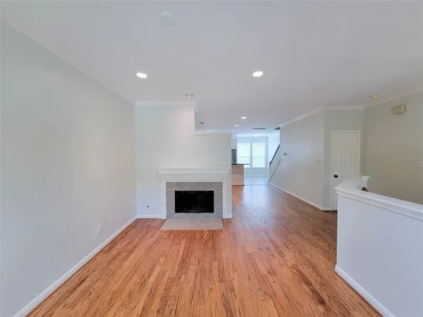 a view of empty room with wooden floor and fireplace