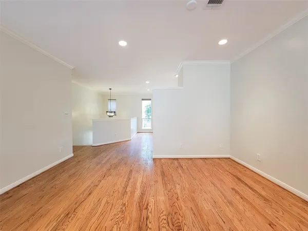 a view of a big room with wooden floor and windows