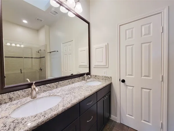 a bathroom with a granite countertop sink and a mirror