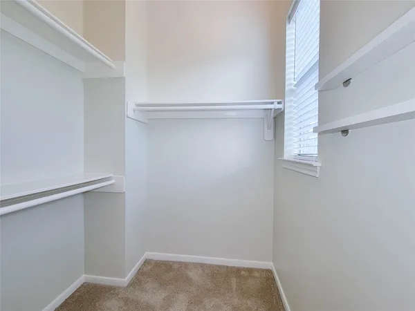 a view of walk in closet with empty racks