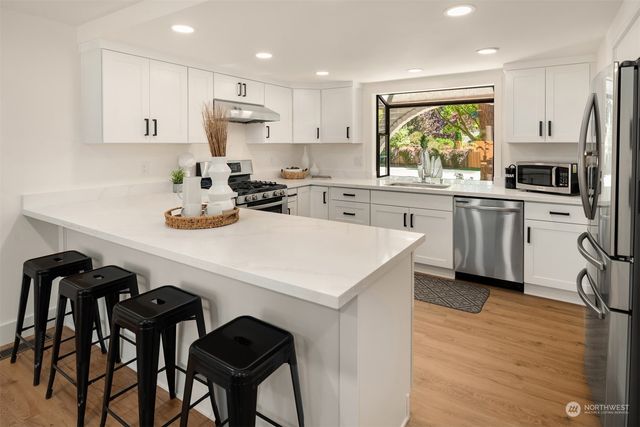 a kitchen with a sink a stove a refrigerator and chairs