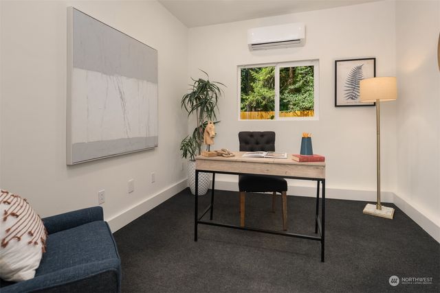 a view of a workspace with furniture and window