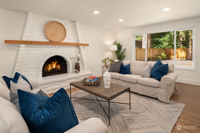 a living room with furniture a fireplace and a large window
