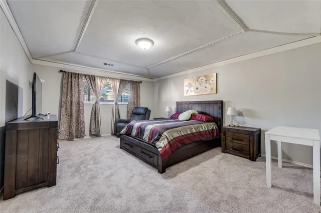 a spacious bedroom with a bed and a chandelier