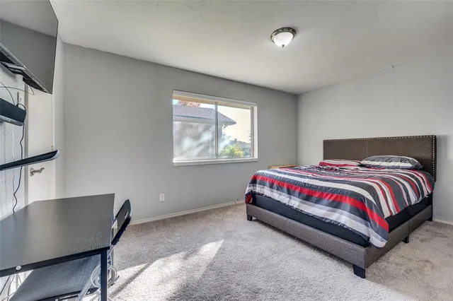 a spacious bedroom with a bed and a window