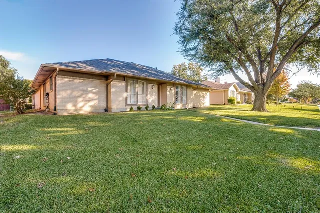 a view of a house with a big yard and large trees