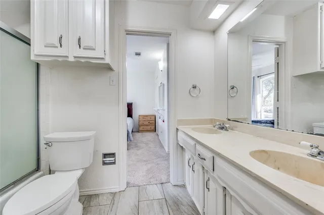 a bathroom with a sink a toilet and a large mirror