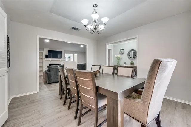 a view of a dining room with furniture and chandelier