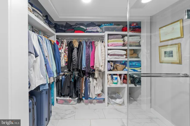 a view of walk in closet with clothes and shoes