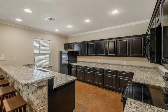 a kitchen with stainless steel appliances granite countertop a stove a sink and a microwave