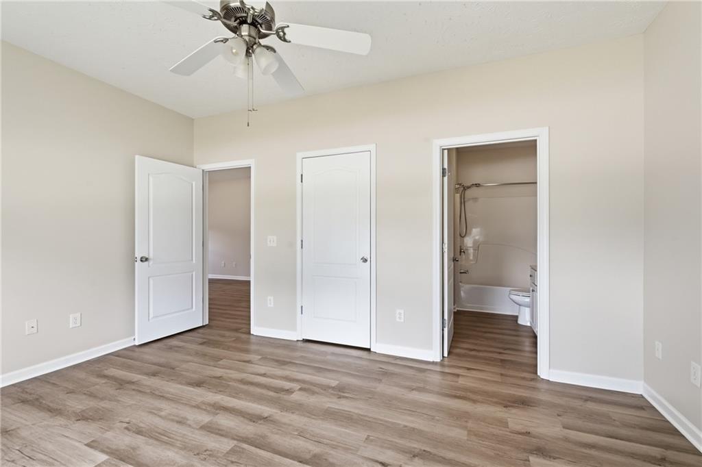4533 Caleb Crossing, Unit 18 Powder Springs, GA 30127 - Photo 18 of 24 a view of a room with wooden floor and a ceiling fan