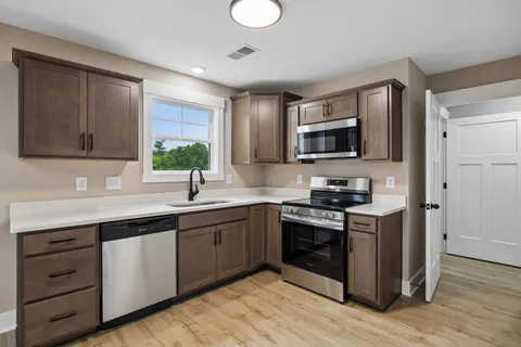 a kitchen with stainless steel appliances granite countertop a sink and stove top oven