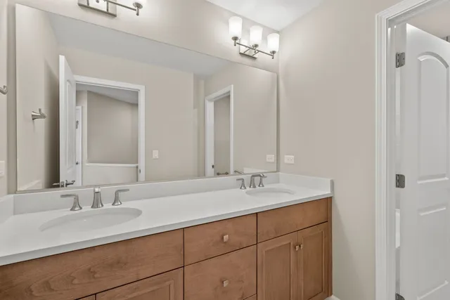 a bathroom with double sink and a mirror