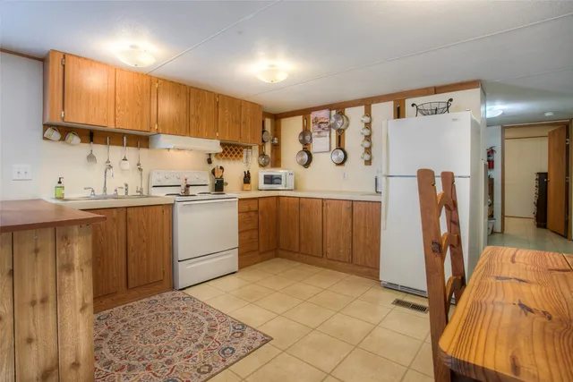 a kitchen with stainless steel appliances granite countertop a sink refrigerator and cabinets