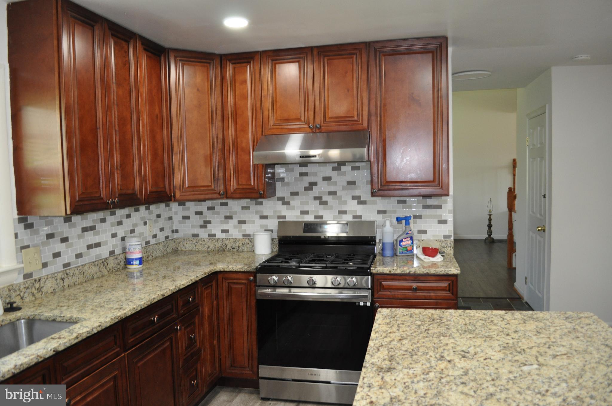 11809 Milbern Drive Potomac, MD 20854 - Photo 11 of 36 a kitchen with granite countertop cabinets and stainless steel appliances