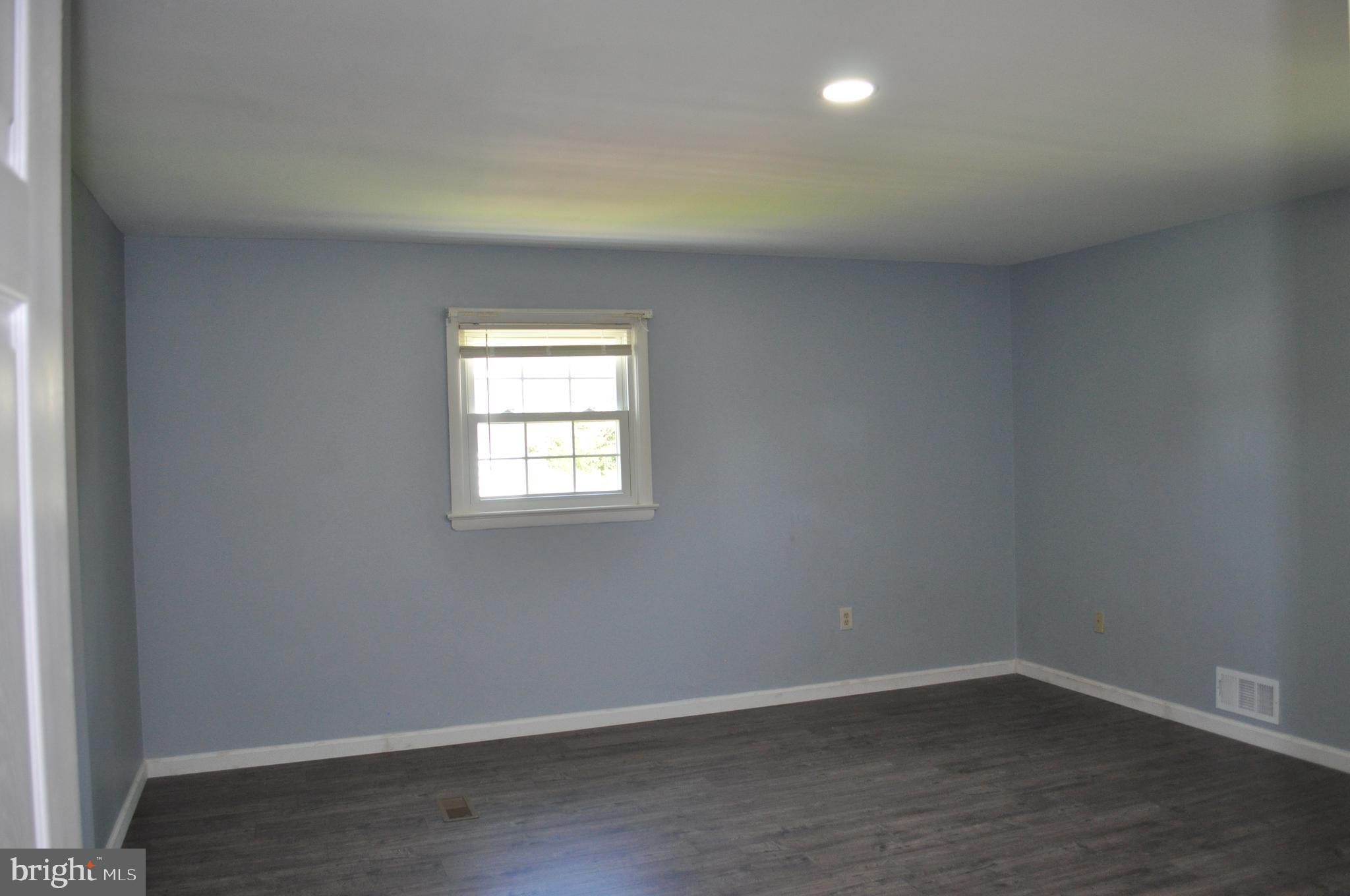11809 Milbern Drive Potomac, MD 20854 - Photo 14 of 36 an empty room with wooden floor and windows