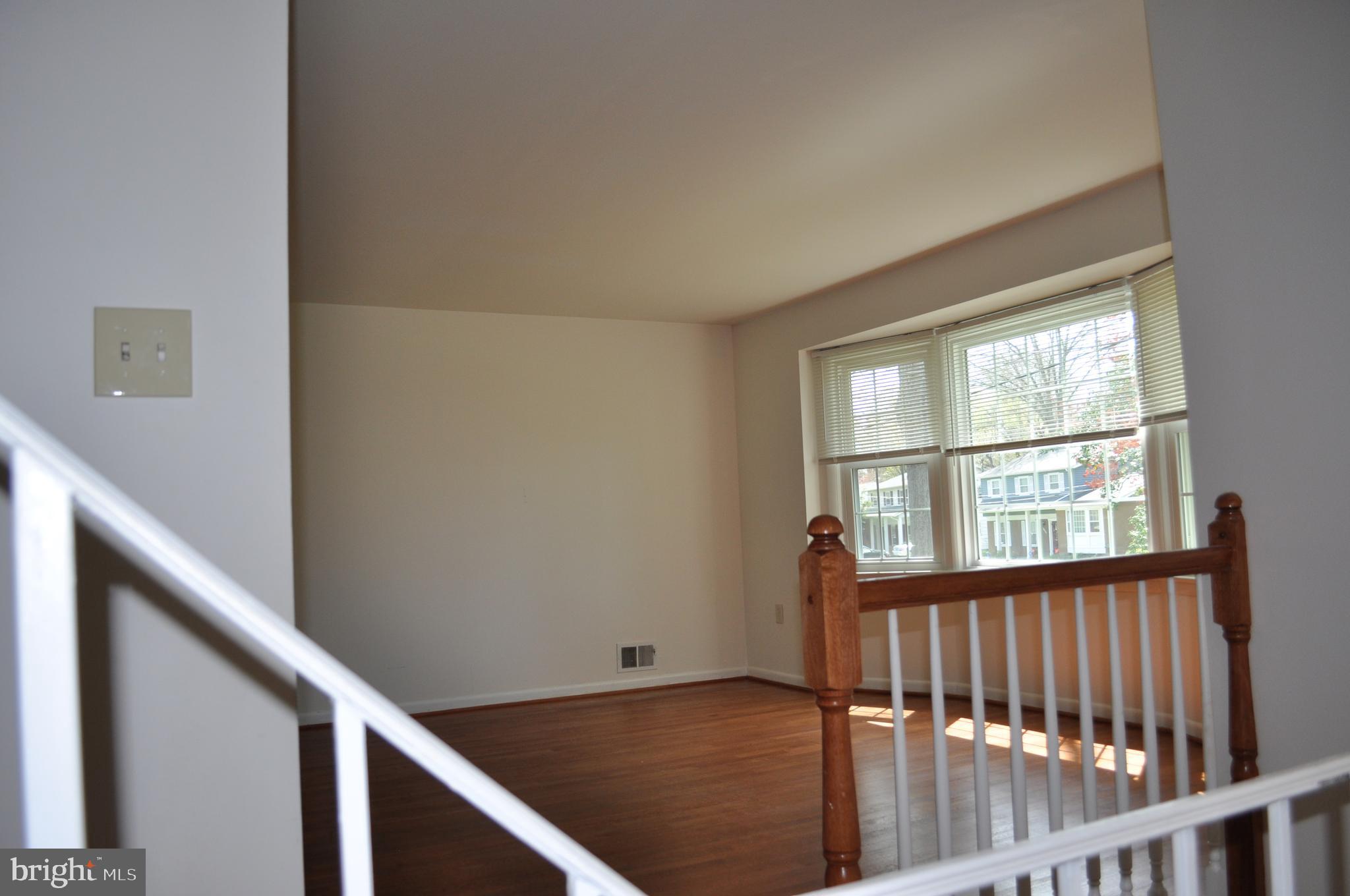 11809 Milbern Drive Potomac, MD 20854 - Photo 20 of 36 a view of an empty room with wooden floor and a window