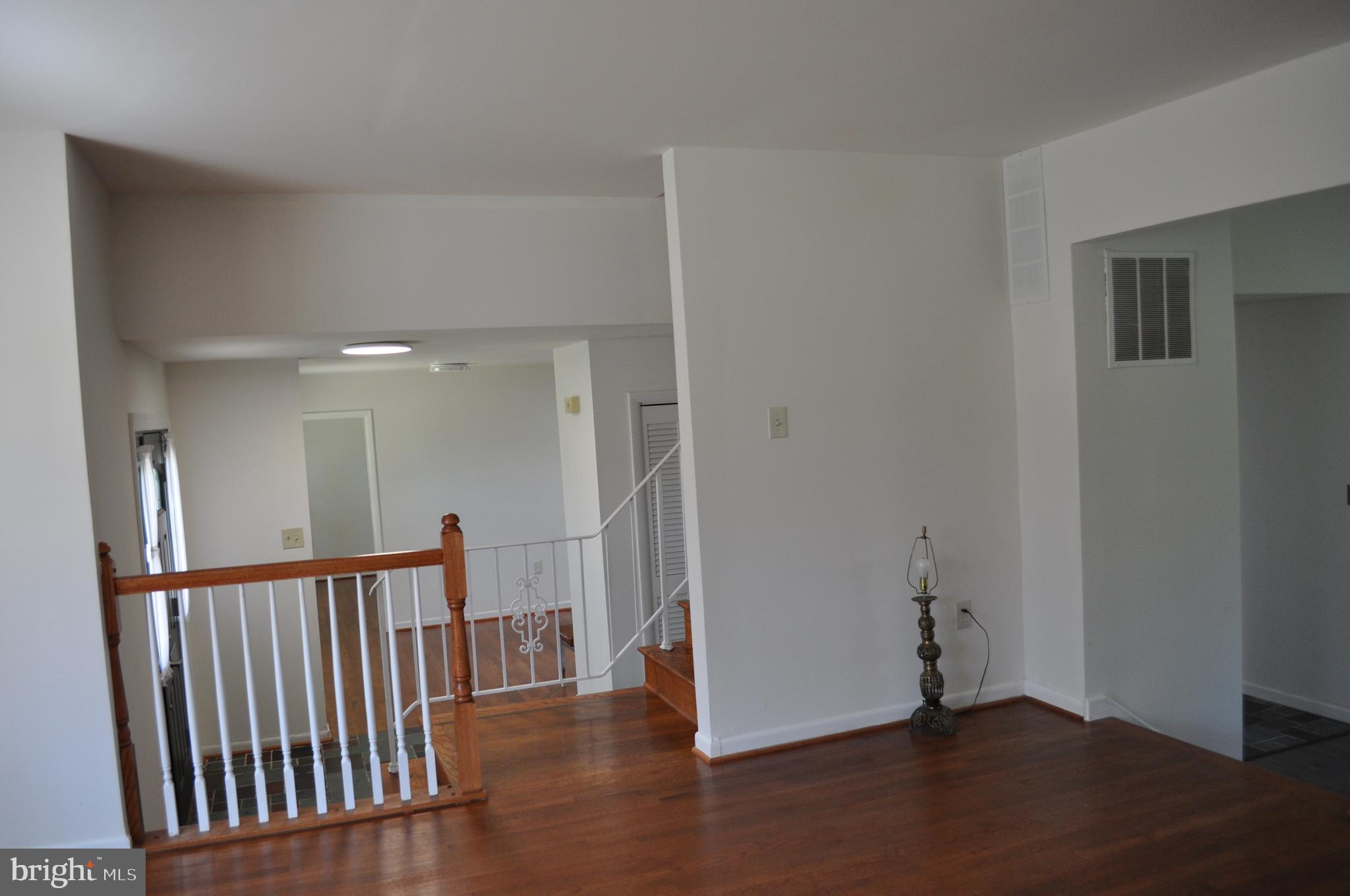 11809 Milbern Drive Potomac, MD 20854 - Photo 21 of 36 a view of a hallway with wooden floor and a window